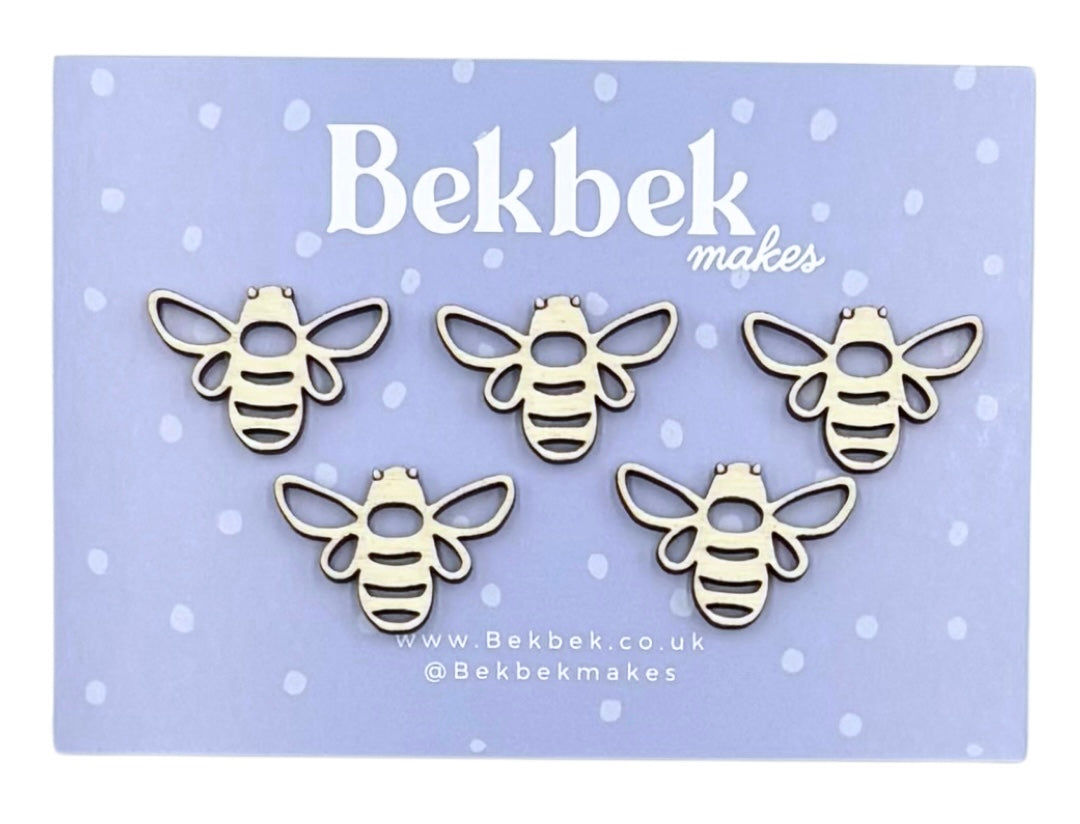Five unfinished wooden bee craft pieces displayed on a light purple card with the brand name 'Bekbek makes' printed at the top.