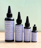 Four bottles of Bekbek Makes UV Resin on a wooden surface with a light green background
